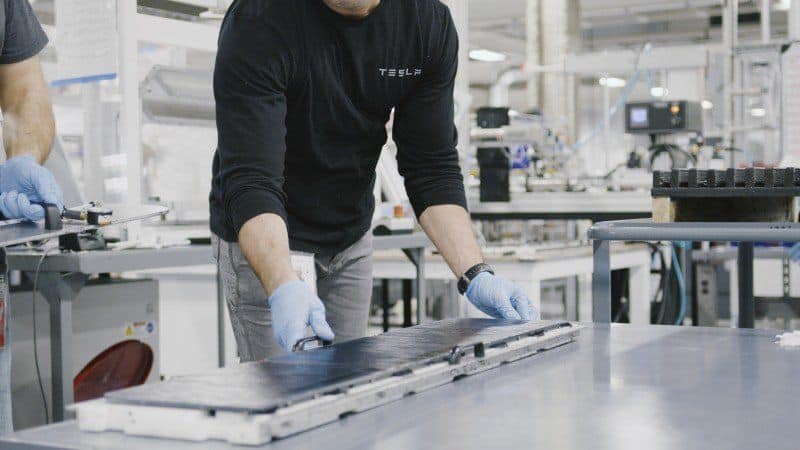 Tesla Mitarbeiter mit Batterie für E-Auto